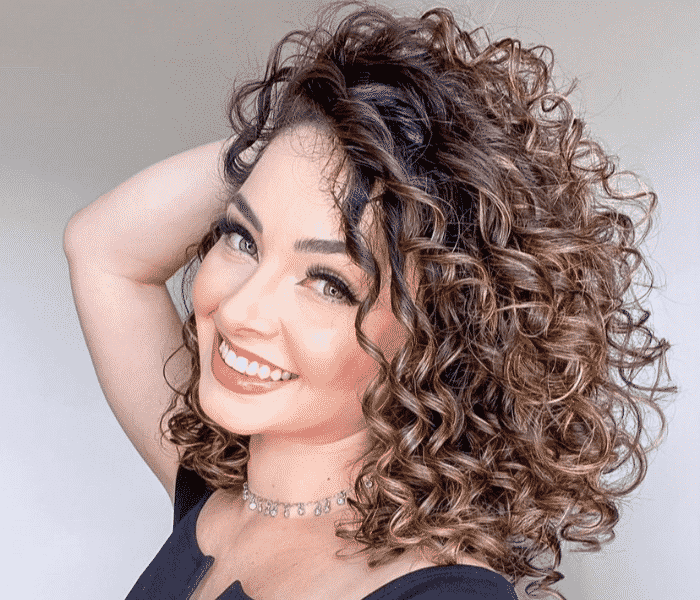 cabelo curto cacheado com mechas iluminadas